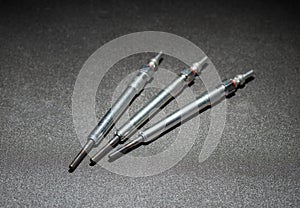 Modern rod ceramic glow plugs for easier starting of a diesel engine in cold weather on a gray background. Automotive