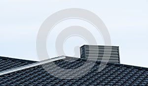 Modern roof made of black metal. Corrugated metal roof and metal roofing. Modern roof made of metal