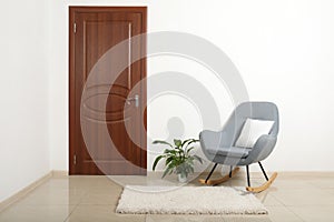 Modern room interior with brown door and rocking chair photo