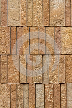 Modern rough textured limestone wall background with vertical aligned stone bricks