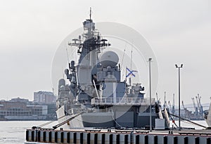 Modern Russian military cruiser battleship on the pierce. Russian Navy Ensign on the ship board. Russia, Vladivostok