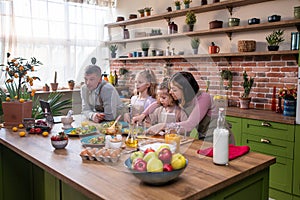 At the modern rustic kitchen island the charismatic dad together with his daughters preparing the breakfast he gives