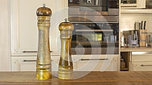 Modern Salt and Classic pepper grinders standing on wood texture table. Salt and pepper shaker on wooden board