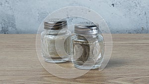 Modern Salt and Classic pepper grinders standing on wood texture table. Salt and pepper shaker on wooden board