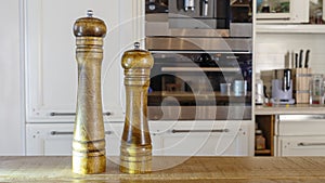 Modern Salt and Classic pepper grinders standing on wood texture table. Salt and pepper shaker on wooden board