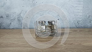 Modern Salt and Classic pepper grinders standing on wood texture table. Salt and pepper shaker on wooden board