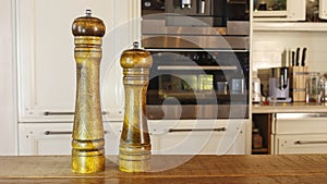 Modern Salt and Classic pepper grinders standing on wood texture table. Salt and pepper shaker on wooden board