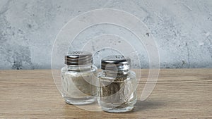 Modern Salt and Classic pepper grinders standing on wood texture table. Salt and pepper shaker on wooden board