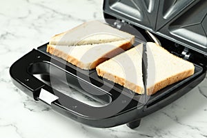 Modern sandwich maker on white marble table, closeup