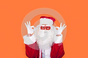 Modern Santa Claus with raised arms doing ring gesture as ok sign