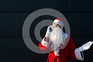 Modern Santa Claus talking on the phone. Ordering the services of an animator for the Christmas and new year. Online greetings via