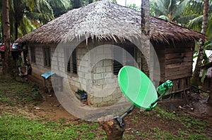 Modern satellite dish next to the shack among the palm trees. Phillipines