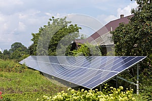 Modern saving efficient stand -alone blue shiny solar photo voltaic panels system producing renewable clean green energy in green