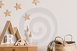 The modern scandinavian newborn baby room with copy space, wooden toys, children accessories, stars on the wall, natural basket.
