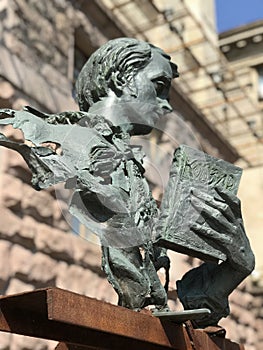 A modern sculpture of a young Taras Shevchenko holding a book of poems