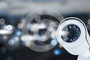 Modern security CCTV camera against blurred background, space for text