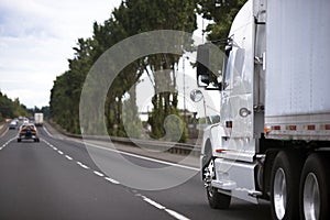 Modern semi truck on wide highway stretching into distance