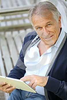 Modern senior man websurfing photo