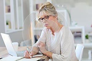 Modern senior woman working on laptop