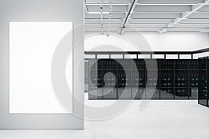 Modern server room interior with blank white mock up poster on concrete wall. Datacenter, security and database concept.