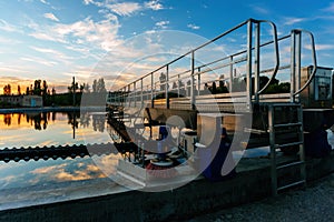 Modern sewage treatment plant. Round wastewater purification tanks at sunset