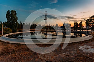 Modern sewage treatment plant. Round wastewater purification tanks at sunset