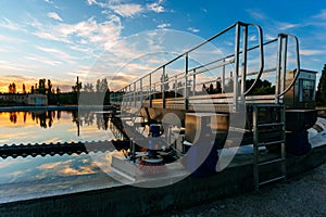 Modern sewage treatment plant. Round wastewater purification tanks at sunset