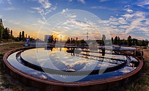 Modern sewage treatment plant. Wastewater purification tanks at sunset