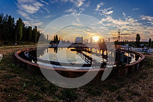 Modern sewage treatment plant. Wastewater purification tanks at sunset