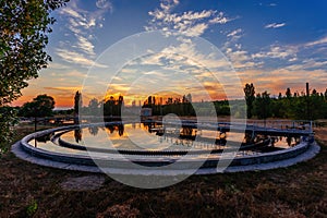 Modern sewage treatment plant. Wastewater purification tanks at sunset