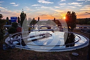 Modern sewage treatment plant. Wastewater purification tanks at sunset, aerial view