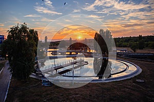 Modern sewage treatment plant. Wastewater purification tanks at sunset, aerial view