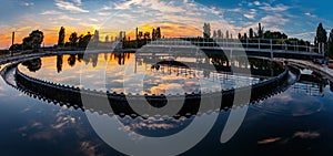 Modern sewage treatment plant. Round wastewater purification tanks at sunset