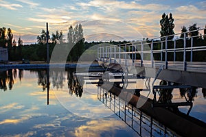 Modern sewage treatment plant. Round wastewater purification tanks at sunset