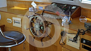 Modern ship control panel with steering wheel and engine accelerators on the captain bridge
