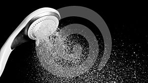 Modern shower head with running water isolated on black background