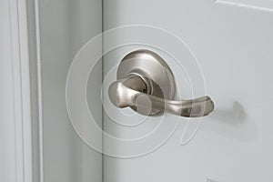 Modern silver door handle on white door