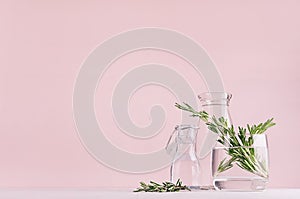 Modern simple art pink home decor with green plant in transparent vases on soft light white wood table.