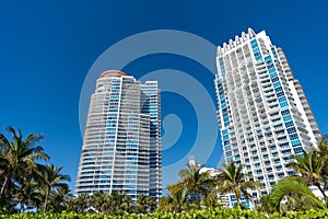 Modern skyscrapers high-rise buildings architecture and palms on blue sky in South Beach, USA