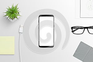 Modern smart phone with round edges on white desk