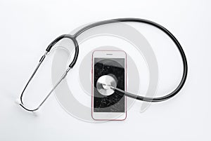 Modern smartphone with broken display and stethoscope on white background. Device repair service