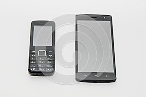 A modern smartphone and a old classic cell phone side by side on a white background