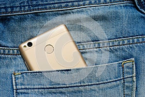 Modern smartphone in the old jeans pocket.