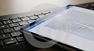 Modern smartphone screen displaying text placed on a computer keyboard