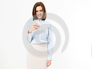 Modern smiling woman looks at something interesting in a mobile phone isolated, girl holding phone