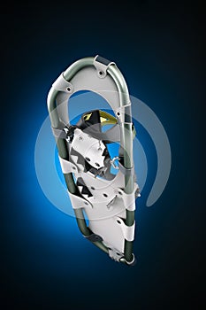 Modern snowshoe under view on gradiant black and blue photo