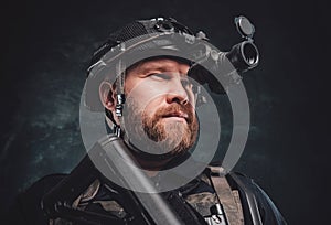 Modern soldier looks in night vision device inbuilt in his helmet