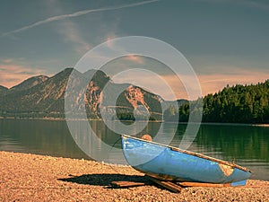 Modern sport fishing paddle boat anchored on shore