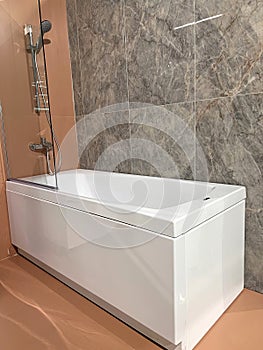 Modern square ceramic bathtub . White tub in minimalistic bathroom interior.