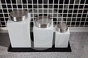 Modern square design storage jars on work surface in black and w